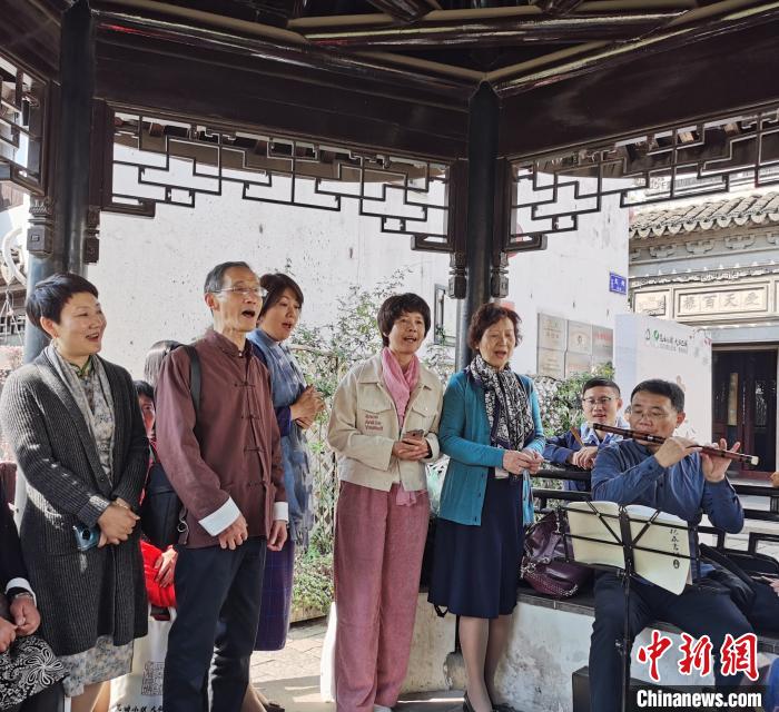 无需繁复的化妆与精致的舞台，兴之所至，曲友们就在小镇路边唱上一曲?！≈由?摄